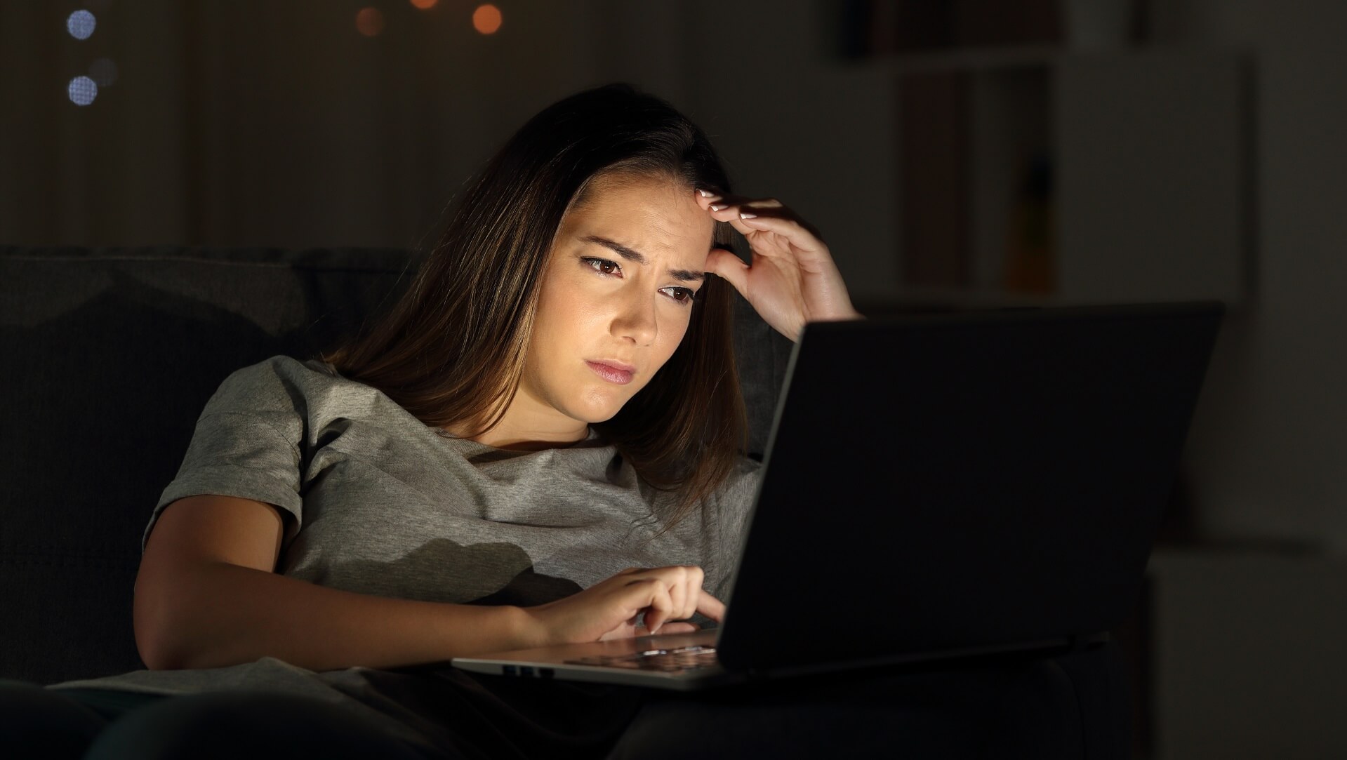 Woman looking at computer to indicate subscribers churning from subscription brands