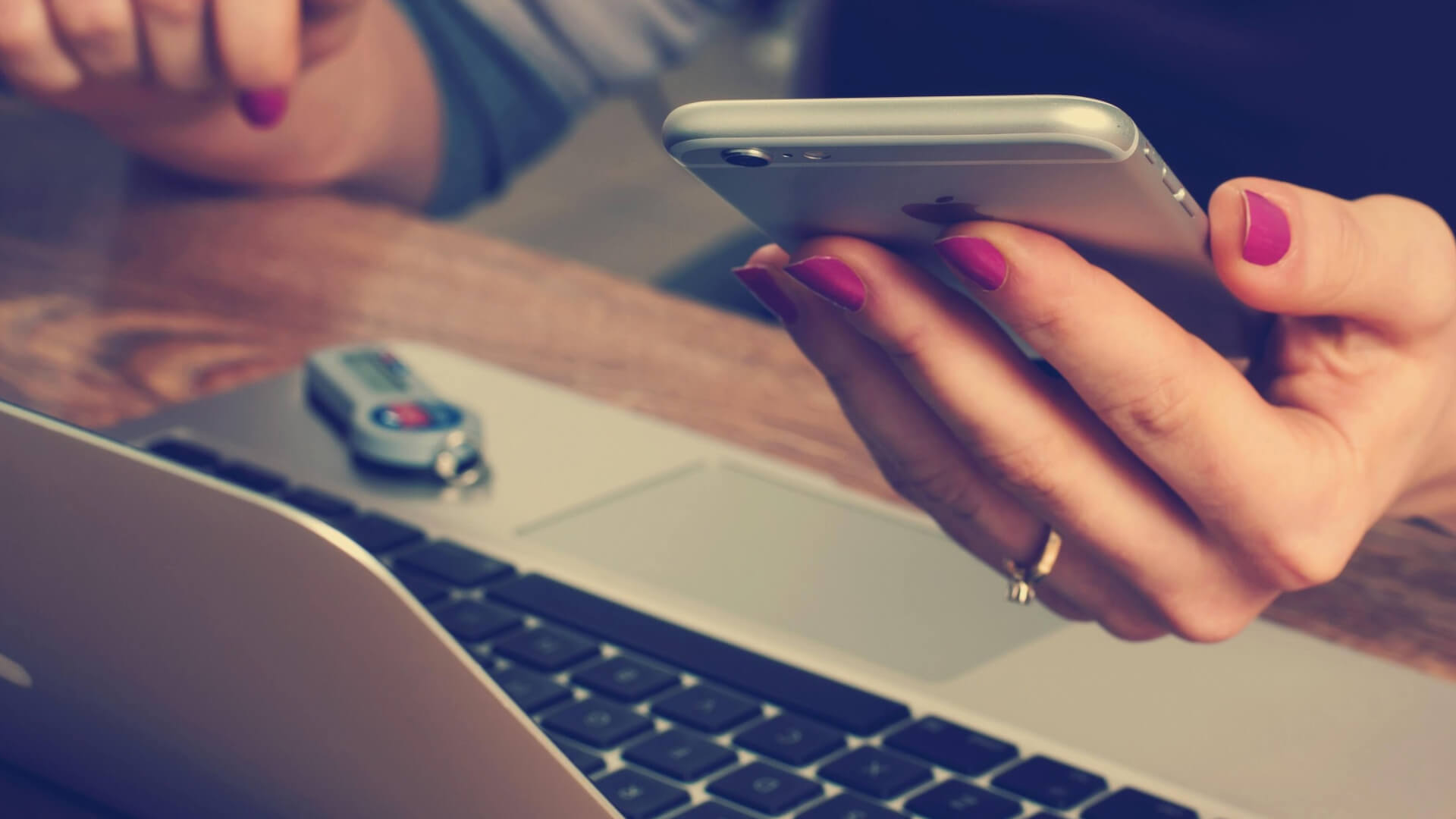 Woman making an email marketing plan on her phone and laptop